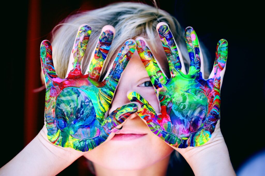 Kid hands are full of colors after painting